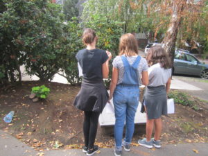 Three guests facing reading slab with poem engraved.