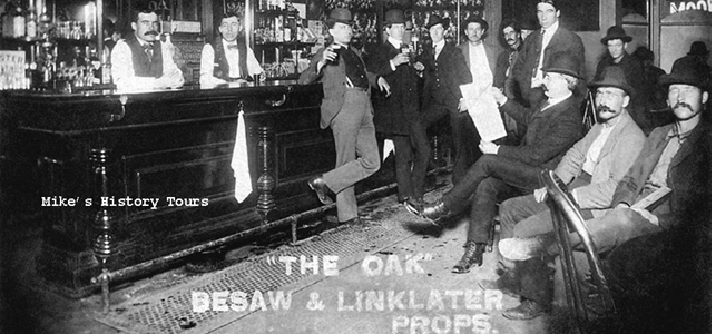 There is a saloon pictured. The men pee right at the bar-there is a grill along its length. Many of these men have mustaches. Text" "The Oak Besaw & Linklater Props. Cor. 23rd And Savier St Portland ORE.