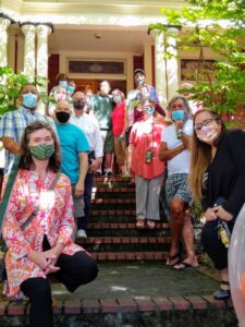 Large group of family and historians in front of Darcelle XV's house in 2020.  All wearing masks.