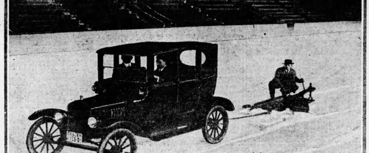 Image of a Ford Car with a driver and pasanger pulling a plow with a man riding it.